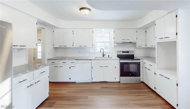 kitchen with white cabinetry, stainless steel appliances, light wood-type flooring, light stone counters, and sink