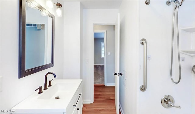 bathroom featuring hardwood / wood-style floors, walk in shower, and vanity