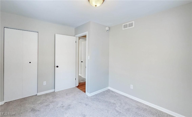 unfurnished bedroom featuring a closet and light carpet