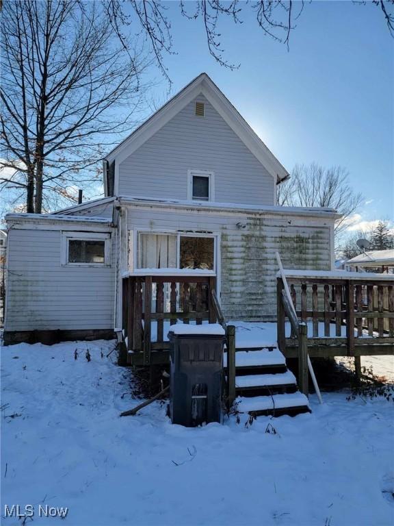 snow covered house featuring a deck