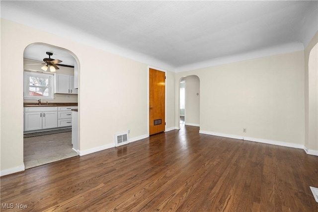 unfurnished room with ceiling fan, dark wood-type flooring, and sink