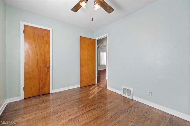 unfurnished room with ceiling fan and dark hardwood / wood-style flooring