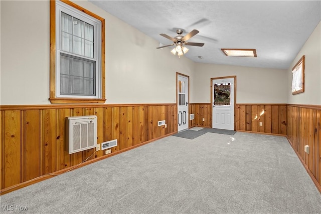 unfurnished room with ceiling fan, light colored carpet, heating unit, and lofted ceiling