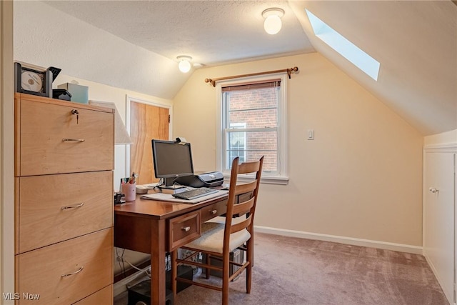 home office with a textured ceiling, lofted ceiling with skylight, and carpet floors