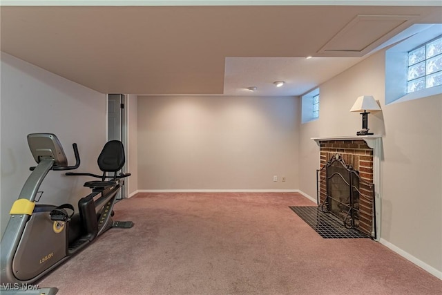 workout room featuring a brick fireplace and carpet flooring