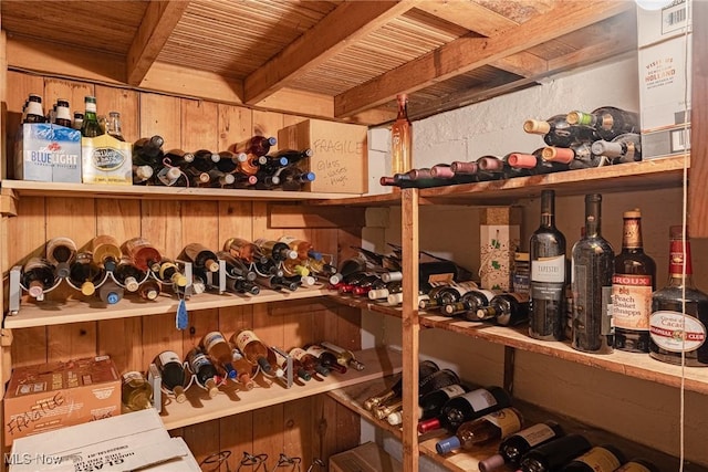 wine cellar featuring beamed ceiling