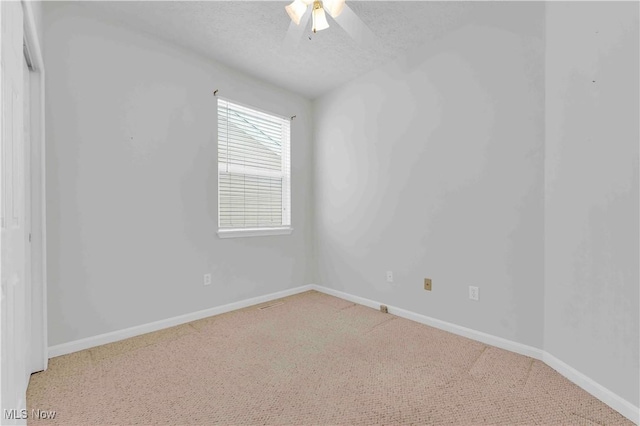 carpeted spare room featuring ceiling fan and a textured ceiling