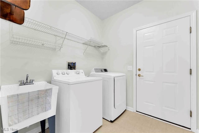 washroom with washer and dryer and sink