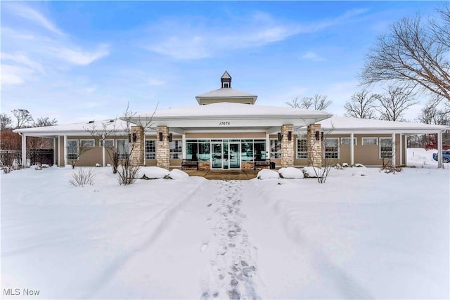 view of snow covered rear of property