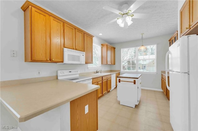 kitchen featuring a textured ceiling, white appliances, hanging light fixtures, kitchen peninsula, and ceiling fan