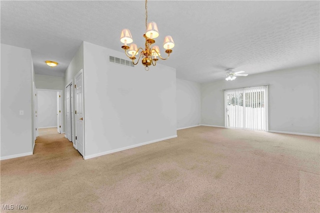 carpeted empty room featuring ceiling fan with notable chandelier and a textured ceiling