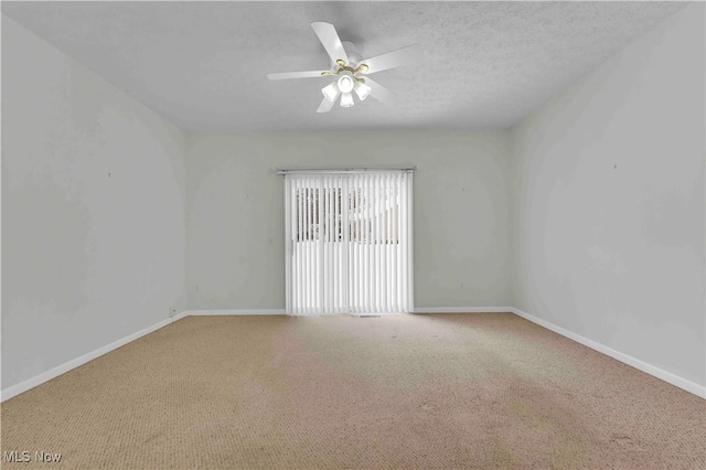 carpeted spare room with ceiling fan and a textured ceiling