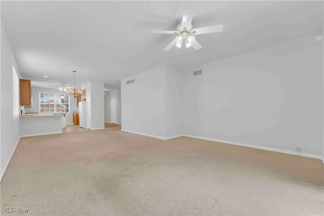 unfurnished living room featuring light colored carpet and ceiling fan with notable chandelier