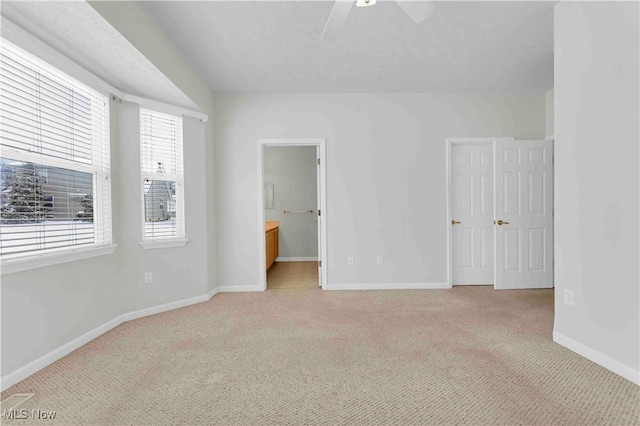 unfurnished bedroom with light colored carpet, connected bathroom, and ceiling fan