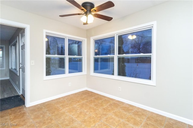 tiled spare room featuring ceiling fan