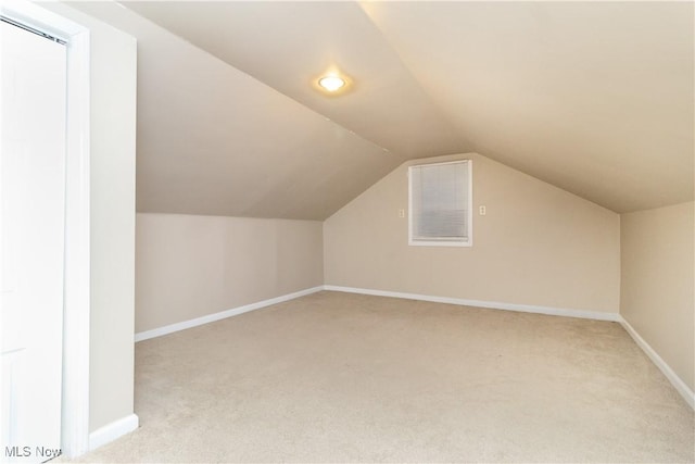 additional living space with vaulted ceiling and light colored carpet