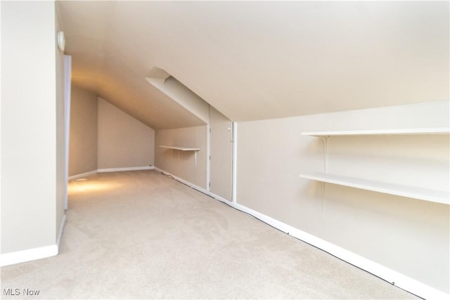 additional living space featuring light carpet and lofted ceiling