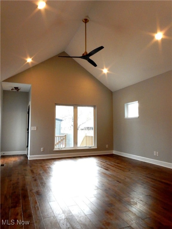 spare room with dark wood-type flooring, ceiling fan, and high vaulted ceiling