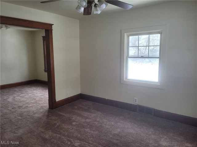 carpeted spare room featuring ceiling fan