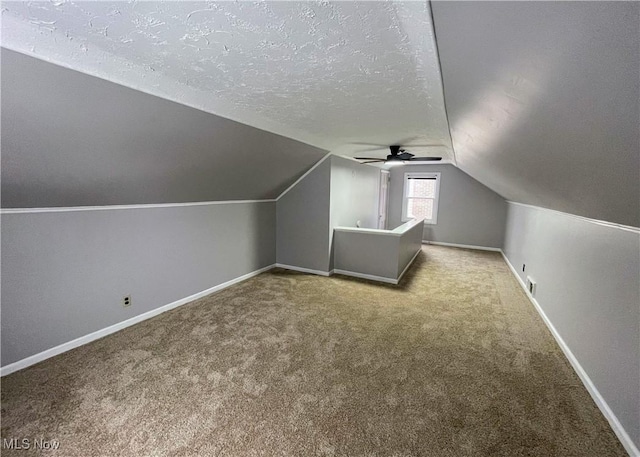 bonus room featuring a textured ceiling, ceiling fan, lofted ceiling, and light colored carpet