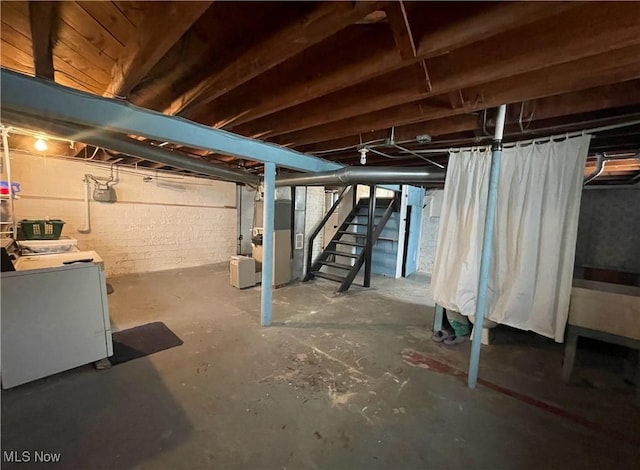 basement featuring heating unit and washing machine and dryer