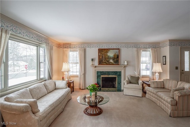 living room with carpet floors, a healthy amount of sunlight, a high end fireplace, and crown molding