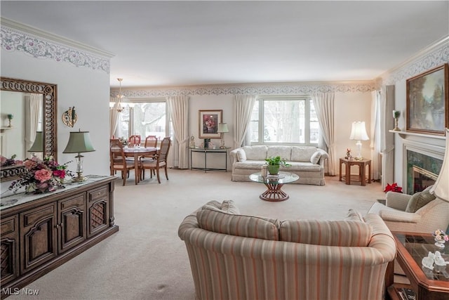 carpeted living room featuring a notable chandelier, a premium fireplace, a healthy amount of sunlight, and crown molding