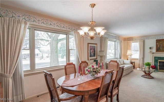 dining area featuring a wealth of natural light, light carpet, a chandelier, and a fireplace