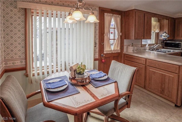 dining area with a healthy amount of sunlight, sink, and light tile patterned flooring