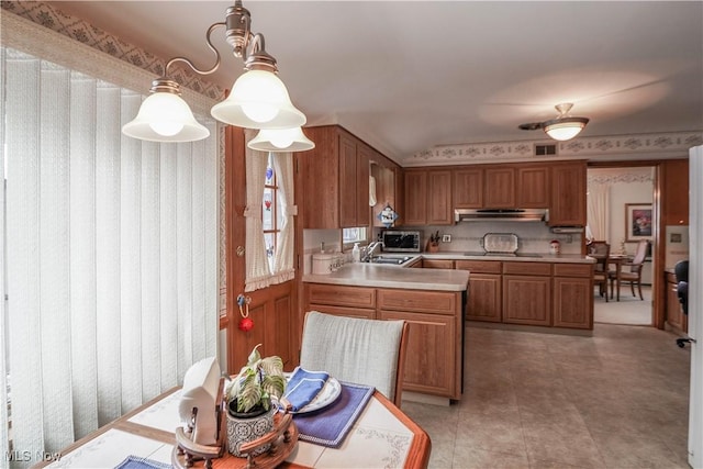 kitchen featuring decorative light fixtures, sink, black electric cooktop, and a chandelier