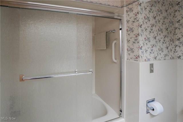 bathroom with shower / bath combination with glass door