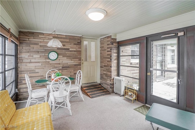 sunroom / solarium featuring radiator heating unit and wooden ceiling