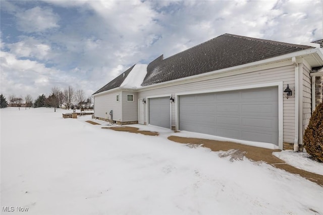 snow covered property featuring a garage