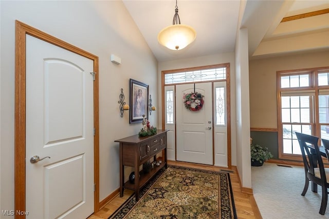 foyer with lofted ceiling and light hardwood / wood-style flooring