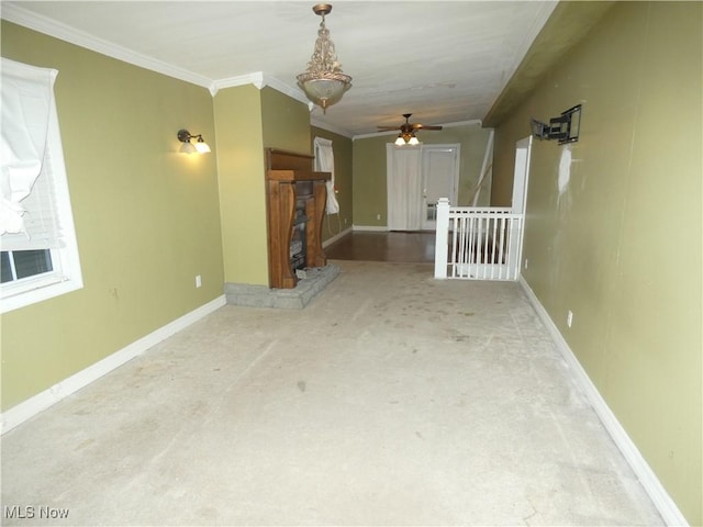 unfurnished living room featuring ceiling fan, carpet, and ornamental molding