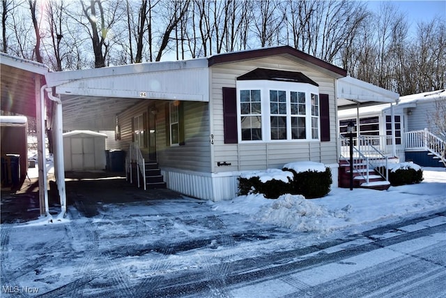 view of front of property with a storage shed and a carport