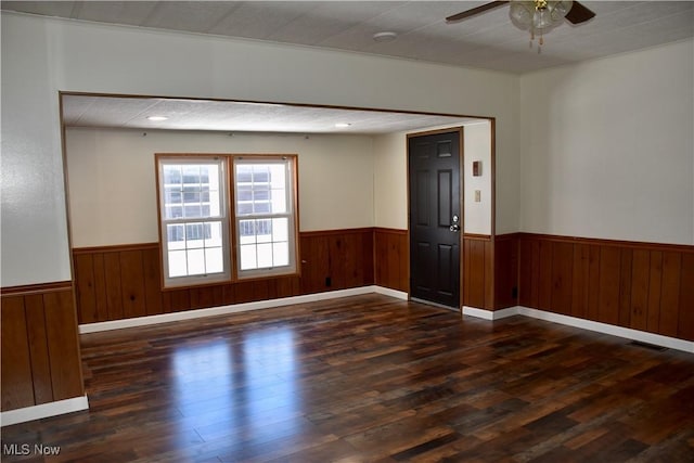 unfurnished room with dark wood-type flooring and ceiling fan