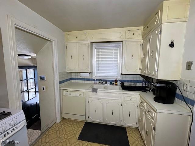 kitchen featuring tasteful backsplash, sink, white appliances, and white cabinetry