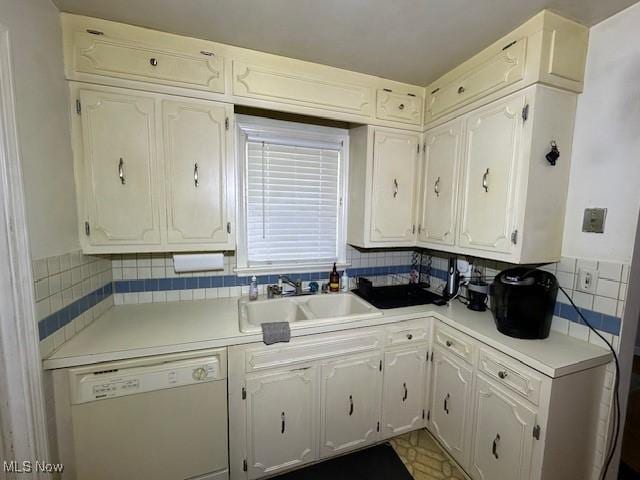 kitchen with tasteful backsplash, dishwasher, sink, and white cabinetry