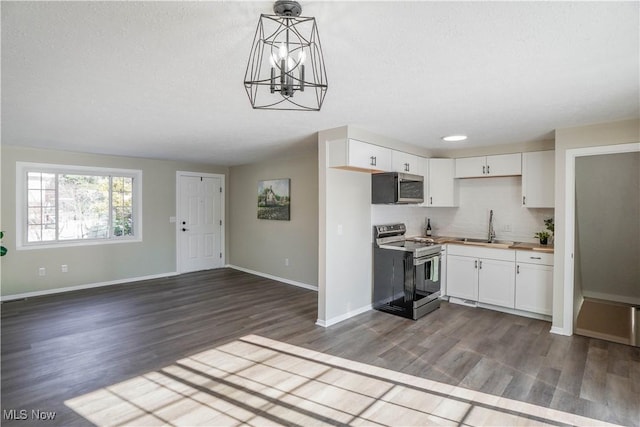 kitchen featuring wooden counters, pendant lighting, sink, appliances with stainless steel finishes, and white cabinets