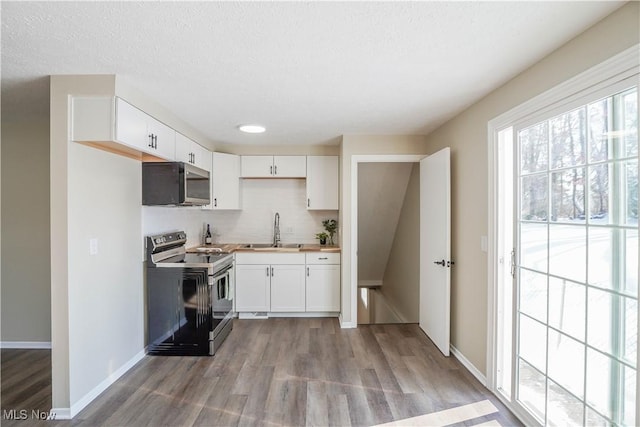 kitchen featuring sink, white cabinets, stainless steel appliances, and light wood-type flooring