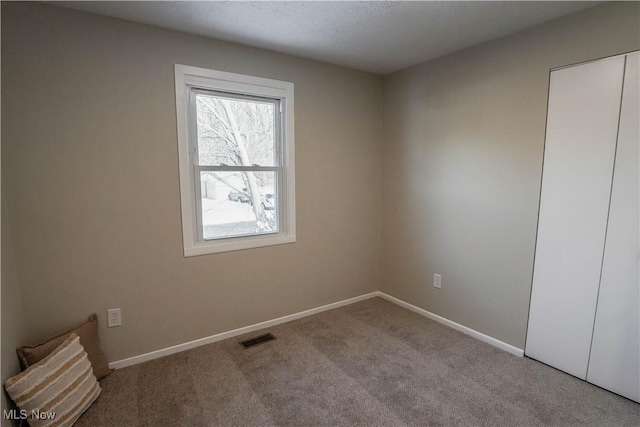 spare room featuring light colored carpet