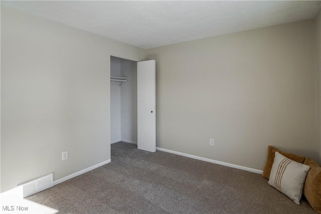 unfurnished bedroom featuring carpet and a closet