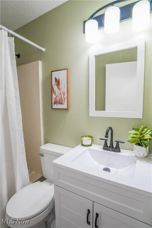 bathroom featuring toilet, vanity, a shower with curtain, and a textured ceiling