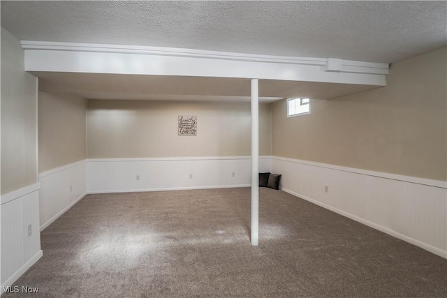 basement featuring carpet floors and a textured ceiling