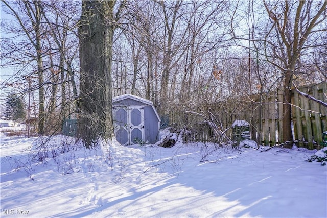 snowy yard with a storage shed