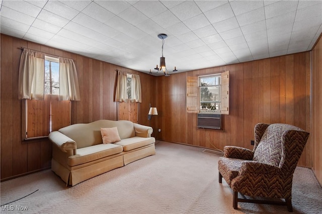 carpeted living room featuring cooling unit, plenty of natural light, and wooden walls