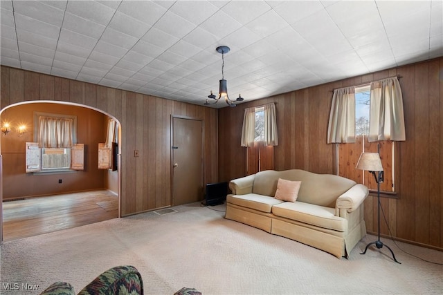 unfurnished living room featuring light carpet and an inviting chandelier