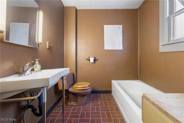 bathroom featuring a tub to relax in and toilet