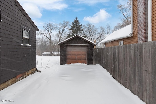 snowy yard with an outbuilding and a garage